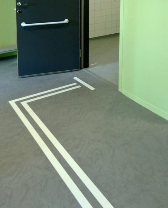 Tactile Flooring ledstråk aluminium 2 mm visar vägen fram till toaletten, med vit kontrastremsa